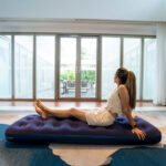 "Woman relaxing on blue inflatable air mattress indoors – Qatar home use", "Inflatable air bed setup on grass outdoor Qatar"